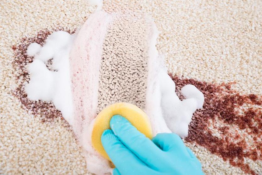 Dep met een doek om het peroxide van het tapijt te verwijderen