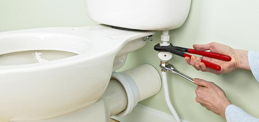 Verwijder de porseleinen of plastic afdekkappen op de vloerbouten waarmee het toilet op de vloer
